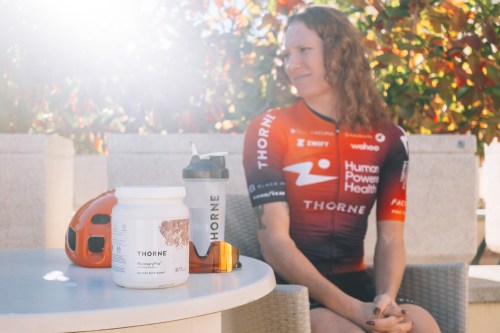 Williams sits at a table with her hands together. Various Thorne products and a shaker sit on the table.